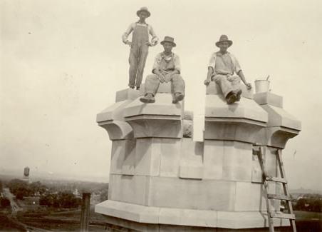 Construction workers hired by J.H. Felt & Co. take a break from their endeavors to pose for a picture on top of one of the Administration Building's signature crown-like turrets.