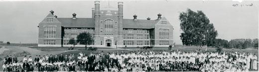 Faculty, staff, and students at Northwest Normal, including the first graduating class, pose for a group picture in front of the Administration Building in 1915.