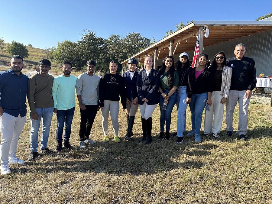Eight graduate students from the School of Computer Science and Information Systems recently created a web application for the Regional Intercollegiate Horse Show Association. The students are pictured while attending a horse show with Dr. Aziz Fellah, associate professor of computer science and information systems (left), and horse show participants. (Submitted photos)