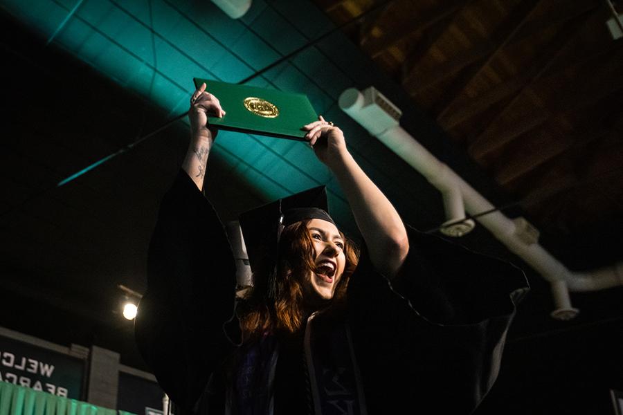 周六，<a href='http://guxuxs.tjkltm.com'>威尼斯人在线</a>的一名毕业生在毕业典礼上展示她的毕业证书.